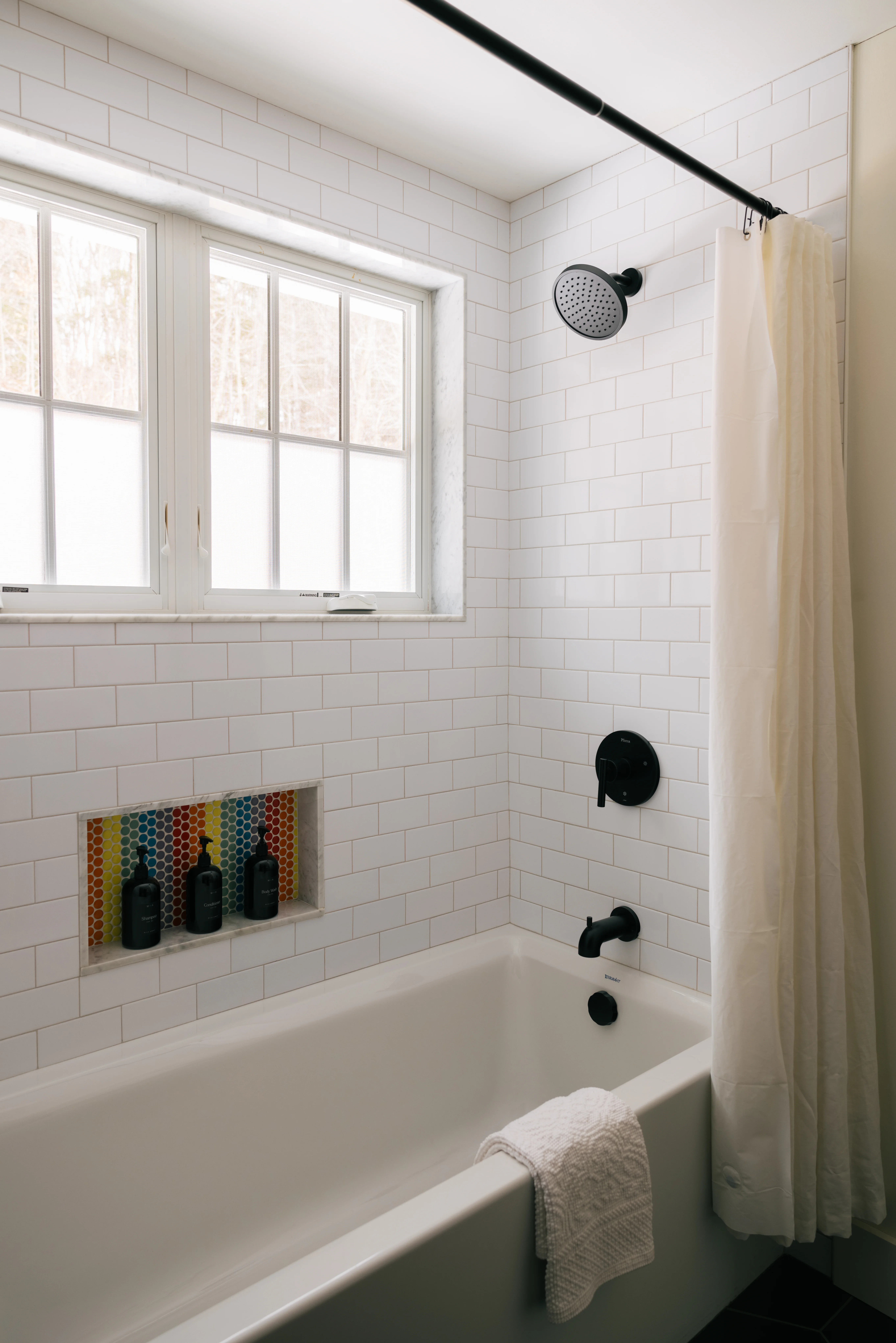 Kids bathroom second view showcasing the shower area and colorful accent tiles